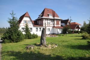 een groot huis met een boom ervoor bij Penzión Chata Valaška in Stary Smokovec