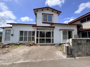 a white house with a driveway in front of it at 長峰駅から徒歩3分ゲストハウスオオワニ in Ōwani