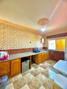 a kitchen with wooden cabinets and a tile floor at اقامة الابرار in Oued Laou +2 photos