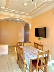 a dining room with a table and chairs and a flat screen tv at اقامة الابرار in Oued Laou