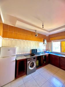 a kitchen with a refrigerator and a washing machine at اقامة الابرار in Oued Laou