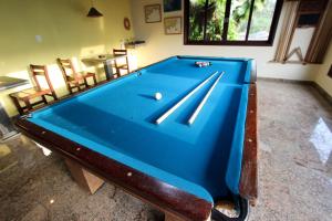una gran mesa de billar azul en una habitación en Pousada Vivenda do Flamboyant, en Ubatuba