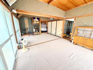 an empty living room with a large window at 長峰駅から徒歩3分ゲストハウスオオワニ in Ōwani