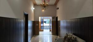 a living room with a chandelier and a couch at Hotel Golden Spark in Jewar