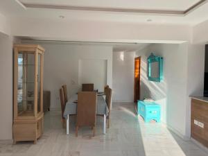 a dining room with a table and a blue cabinet at Dar El Baraka in Ghar el Fabs