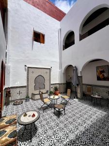 a patio with tables and chairs on a tile floor at Riad Maison Eden in Rabat