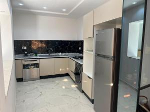 a kitchen with white cabinets and a stainless steel refrigerator at Dar El Baraka in Ghar el Fabs