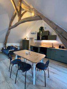 a kitchen and dining room with a wooden table and chairs at Le Nid - Pause en Berry in Vignoux-sur-Barangeon