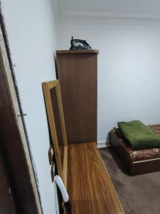 ein Zimmer mit einem Holzstuhl und einem Bett in der Unterkunft ريماس 13 in Irbid