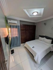 a bedroom with a large white bed in a room at Résidence ivoire in Yamoussoukro
