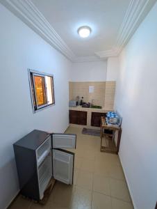 a kitchen with white walls and a black counter at Résidence ivoire in Yamoussoukro
