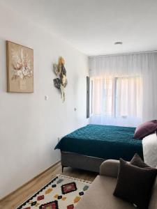 a bedroom with a green bed and a couch at Apartment Melina in Plužine