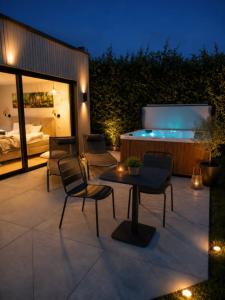 a patio with a bed and a table and chairs at Le Cocon, Jacuzzi privé Spa Francorchamps in Spa