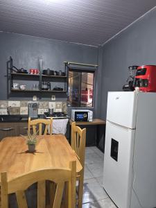 a kitchen with a table and a white refrigerator at Hummingbird Hostel in Ciudad del Este +31 photos