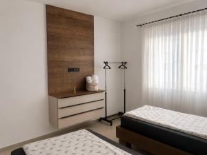a bedroom with two beds and a dresser and a window at Villa Elaris in Bihać