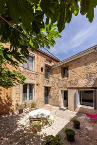 an old stone building with a table in the courtyard at Le Patio in Gevrey-Chambertin