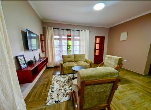 a living room with two chairs and a table at Kijani Pazuri Cottages in Lushoto