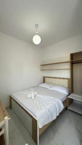 a bedroom with a large bed with white sheets at Vila Roan in Vlorë
