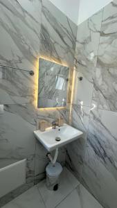 a white bathroom with a sink and a mirror at Vila Roan in Vlorë +74 photos