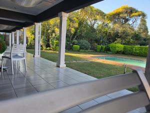 a porch with chairs and a view of a pool at Southernstar 10 st Davids road in Arcadia