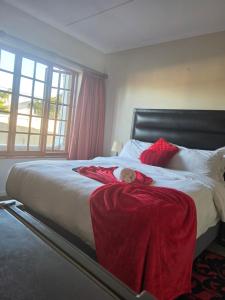 a bedroom with a bed with a doll laying on it at Southernstar 10 st Davids road in Arcadia +18 photos