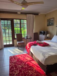 a bedroom with a large bed with a red blanket on it at Southernstar 10 st Davids road in Arcadia