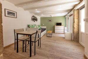 a living room with a table and a couch at Le Patio in Gevrey-Chambertin
