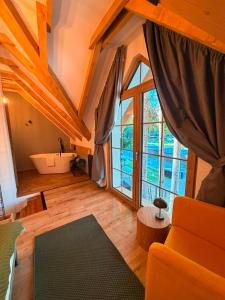 a living room with a large window and a tub at Tiny Jazz in Gărâna +62 photos