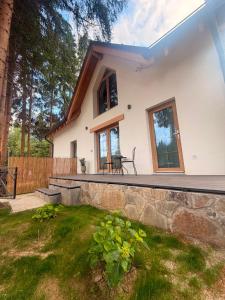 a house with a stone retaining wall and a patio at Tiny Jazz in Gărâna