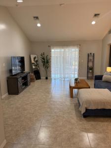a living room with a couch and a tv at Seras Home At Vero Beach in Vero Beach