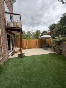 a backyard with a patio with a table and an umbrella at The Warwick Room in Warwick