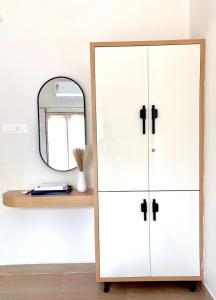 a dressing room with a mirror and a white cabinet at Meadows Homestay Elite in Madurai