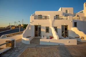 a white house with stairs on the side of it at Stilvi Mykonos in Ornos