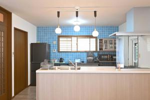 a kitchen with a counter and blue tiles at Fuka in Beppu -New Open January2026 in Beppu