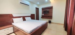 a bedroom with a bed and a television in it at hotel celebrations in Jāmb