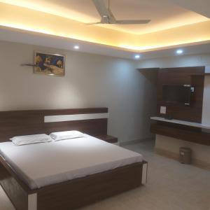 a bedroom with a bed and a flat screen tv at hotel celebrations in Jāmb +1 photo