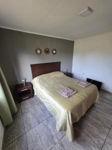 a bedroom with a bed with a wooden head board at arrayanes in Junín +8 photos