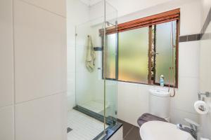 a bathroom with a glass shower and a sink at Bryanston stays in Johannesburg +13 photos