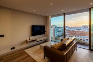 a living room with a couch and a flat screen tv at The View at the Downtown 5 in Faro