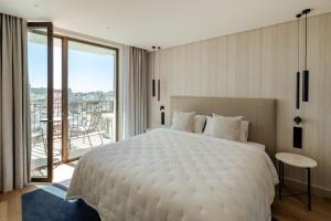 a bedroom with a white bed and a large window at The View at the Downtown 5 in Faro