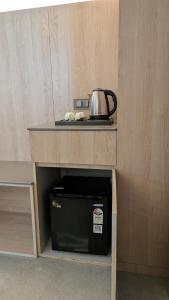 a microwave under a table with a pot on it at Hotel Grande Court in Kharar
