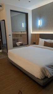 a large bed in a bedroom with a large window at Hotel Grande Court in Kharar