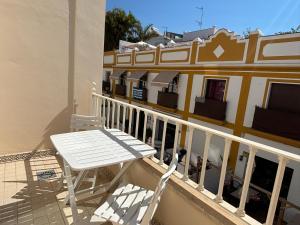 a white table and chairs on a balcony with a building at Plaza España - Nerja centro in Nerja