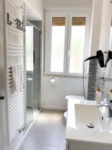 a white bathroom with a shower and a sink at Solution Timone - Appartamento al mare in Punta Marina +10 photos