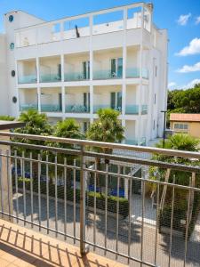 a white building with trees in front of it at Solution Timone - Appartamento al mare in Punta Marina