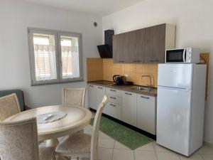 a kitchen with a table and a white refrigerator at Asfodelo in Galtellì