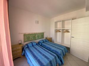 a bedroom with a bed with a blue comforter at Asfodelo in Galtellì