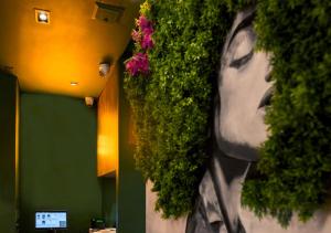 a wall with plants on the side of a building at Sloh Hotel & Bar Manila Medellin in Medellín