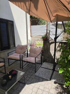 a patio with two chairs and an umbrella at Charming Home with Private Patio near Swiss Border and Transport - Daisy, Loggiadeifiori in Como