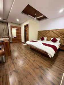 a bedroom with a large bed and a wooden floor at Pari Shree Hotel And Banquet in Rānchī